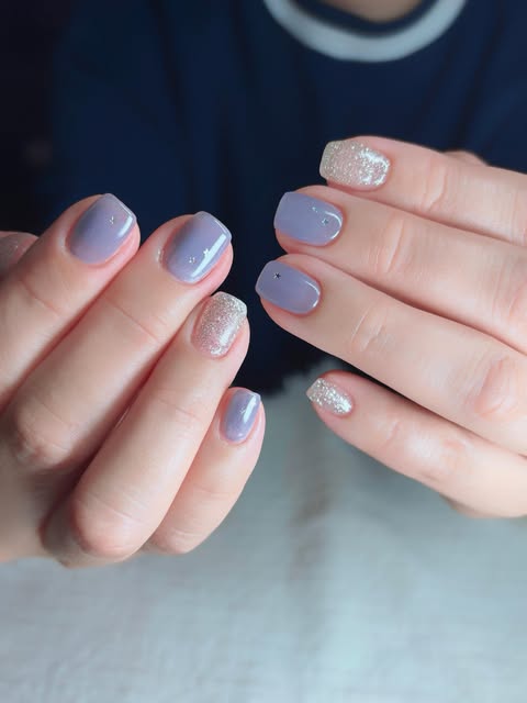 Dusty periwinkle short nails with silver glitter accents.
